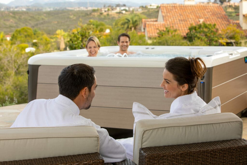 A couple in white robes and chair consider buying a hot tub from a local dealer