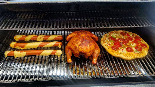pellet grills with hot dogs, chicken, and a pizza